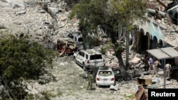 Security personnel are seen next to buildings damaged at the scene where a suicide car bomb exploded targeting a Mogadishu hotel in a business center in Maka Al-Mukaram street in Mogadishu, Somalia, March 1, 2019. 