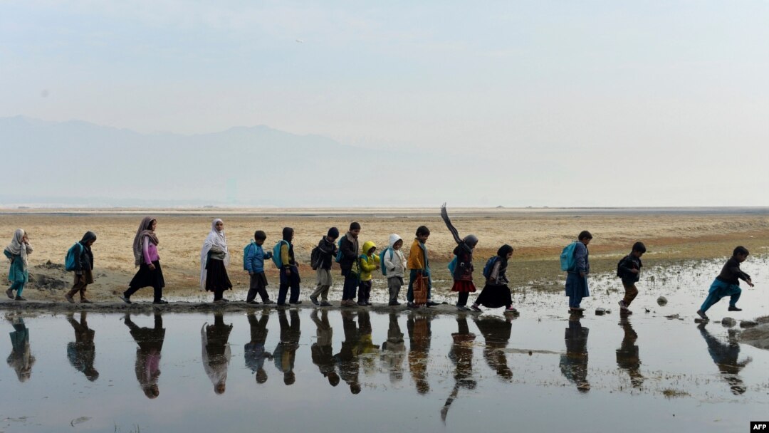 Niños en edad escolar caminan para participar en una clase en un aula al aire libre en el distrito de Qarghayi, de la provincia de Laghman, el 20 de enero de 2020.