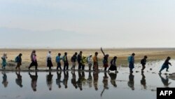 Niños en edad escolar caminan para participar en una clase en un aula al aire libre en el distrito de Qarghayi, de la provincia de Laghman, el 20 de enero de 2020.