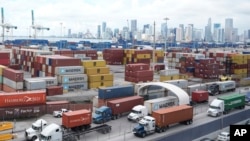 Trucks line up to enter Port Miami after the union representing 45,000 striking U.S. dockworkers reached a deal to suspend a three-day strike, Oct. 4, 2024, in Miami. 