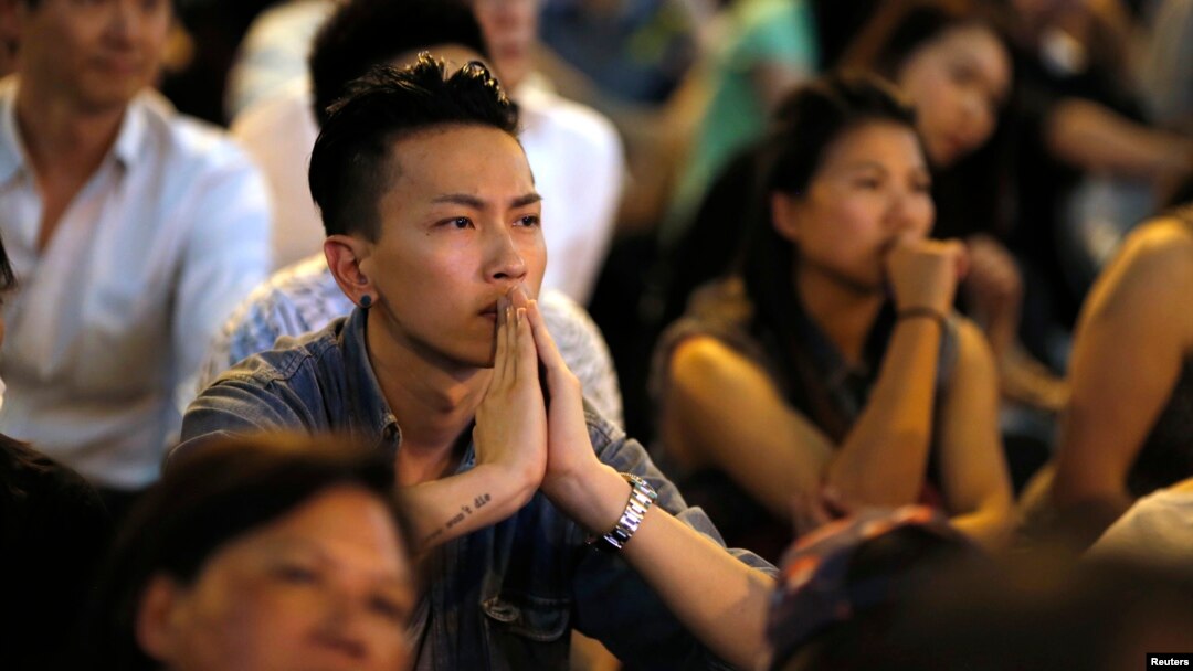 Manifestantes prodemocracia observan las conversaciones entre los líderes de la protesta y oficiales de la ciudad de Hong Kong.