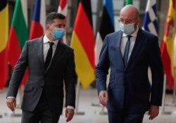 FILE - Ukrainian President Volodymyr Zelenskiy, left, is welcomed by European Council President Charles Michel ahead of an EU-Ukraine summit at the European Council in Brussels, Oct. 6, 2020.