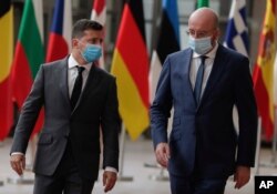 FILE - Ukrainian President Volodymyr Zelenskiy, left, is welcomed by European Council President Charles Michel ahead of an EU-Ukraine summit at the European Council in Brussels, Oct. 6, 2020.