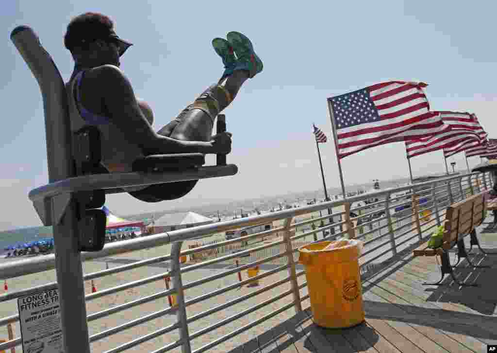 Karma Scott does leg lifts at a fitness station on the boardwalk in Long Beach, New York.