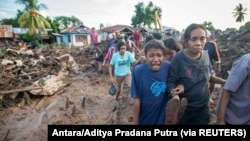 Seorang perempuan menangisi kerabatnya yang ditemukan tewas usai hujan deras membawa banjir bandang di Flores Timur, Nusa Tenggara Timur, 6 April 2021. (Foto: Antara/Aditya Pradana Putra via REUTERS)