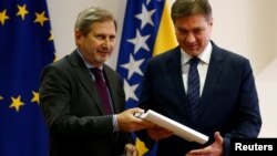 European Union enlargement commissioner Johannes Hahn hands the Questionnaire of the European Commission to Bosnian Prime Minister Denis Zvizdic in Sarajevo, Bosnia and Herzegovina, Dec. 9, 2016.