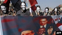 Protesters wear masks depicting slain Coptic activist Mina Daniel while carrying a banner picturing Egypt's military rulers and ousted President Hosni Mubarak as they march in the suburb of Shobra, on their way to join a rally in Tahrir Square in Cairo, E
