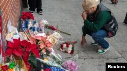 A man reacts at a makeshift memorial at the scene where two police officers were fatally shot in the Brooklyn borough of New York, Dec. 21, 2014. The two New York City police officers, Wenjian Liu and Rafael Ramos, were shot and killed as they sat in a ma