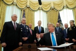FILE - U.S. President Donald Trump looks to Vice President Mike Pence during a signing ceremony to establish a Space Force as part of the U.S. Armed Forces, in the Oval Office at the White House in Washington, Feb. 19, 2019.