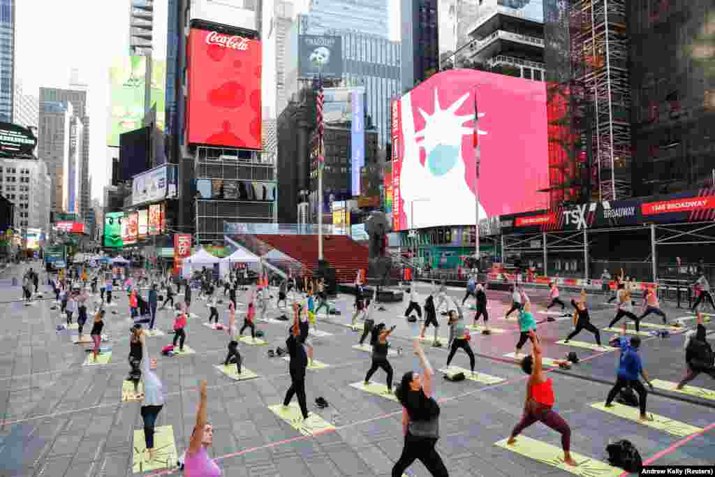 Pessoas participam no evento de celebra&#231;&#227;o do solst&#237;cio na Times Square em Nova Iorque (&quot;Solstice in Times Square: Mind Over Madness Yoga&quot;). 20 de Junho, 2021