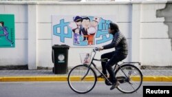 2018年2月26日，上海街道上一幅描绘中国国家主席习近平和医生、厨师、警察等人在一起的漫画，上面写着“中国梦”。