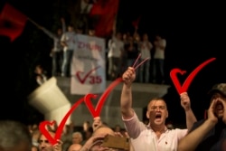 FILE - Supporters of the opposition party "Vetevendosje" hold heart signs during the closing election campaign rally in Kosovo capital Pristina, June 9, 2017.