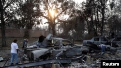 Maria Arevalo, left, and her husband, Antonio Silva, search for items to salvage in the remains of their home that was destroyed by a wildfire in Phoenix, Ore., Sept. 22, 2020.