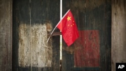 Bendera nasional China terlihat dipajang di sebuah gang tradisional di Beijing, China, pada 7 Juli 2024. (Foto: AP)