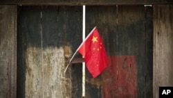 FILE - A Chinese national flag is displayed on a door in a traditional alleyway in Beijing, China, July 7, 2024. An advocacy group estimates that 11 U.S. nationals are currently wrongfully detained in China.