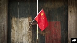 FIle - Bendera nasional China dipajang di luar gang tradisional Hutong di Qianmen, Beijing, China, 7 Juli 2024. (Vincent Thian/AP) 