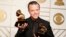 Jason Isbell holds the awards for Best Americana Album and Best American Roots Song during the 58th Grammy Awards in Los Angeles, Feb. 15, 2016. 