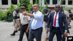 FILE - Haitian interim Prime Minister Garry Conille points as he walks with Police Chief Normil Rameau, left, in Port-au-Prince, Haiti, July 9, 2024. 