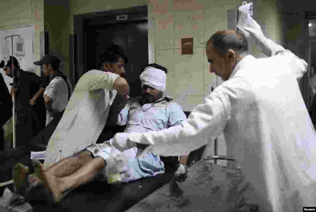 Medics attend to a man wounded in a bomb blast at a vegetable market in Islamabad April 9, 2014.