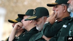 In this June 30, 2018 photo, released by an official website of the office of the Iranian supreme leader, Gen. Qassem Soleimani, center, who heads the elite Quds Force of Iran's Revolutionary Guard attends a graduation ceremony of a group of the guard's o