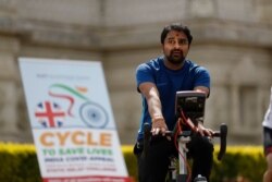 A man takes part in "Cycle to Save Lives," a 48-hour nonstop static relay cycle challenge, at the Neasden Temple, the largest Hindu temple in the U.K., in north London, to raise money to help coronavirus relief efforts in India, May 1, 2021.