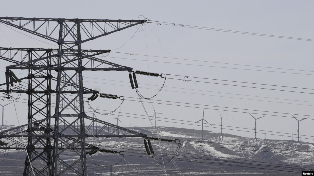 Torres eléctricas y turbinas de viento de la corporacion china State Grid se observan en una foto en la provincia de Hebei.