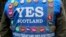 FILE - A man wears a multitude of 'yes' campaign badges during a pro-independence march in Edinburgh for the September vote on Scotland's independence from the United Kingdom.