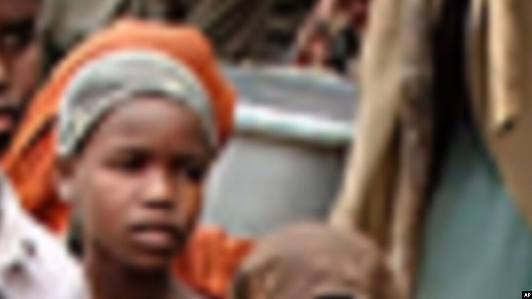 Wasu mata da yara a Mugadishu suke karbar abinci da aka dafa.