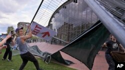 Manifestantes quitan barricadas que habían sido colocadas afuera de un campamento de protesta pro-palestinos en el Instituto de Tecnología de Massachusetts (MIT por sus siglas en inglés), el lunes 6 de mayo de 2024, en Cambridge, Massachusetts.