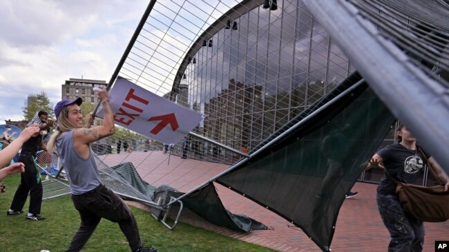 Manifestantes quitan barricadas que habían sido colocadas afuera de un campamento de protesta pro-palestinos en el Instituto de Tecnología de Massachusetts (MIT por sus siglas en inglés), el lunes 6 de mayo de 2024, en Cambridge, Massachusetts.