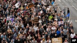 FILE - Demonstrators protesting the dismissal of the editor-in-chief of the Hungarian news website Index.hu march in the streets of Budapest, Hungary, July 24, 2020.