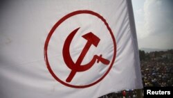 A party flag of the Unified Communist Party of Nepal (Maoist) above the crowd during a mass gathering in Kathmandu, June 15, 2012. 