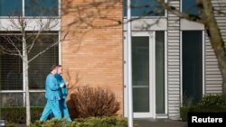 Employees in scrubs walk on the campus at Providence Regional Medical Center after a traveler from China was reported to be the first person in the U.S. to be diagnosed with the Wuhan coronavirus, in Everett, Washington, Jan. 21, 2020.