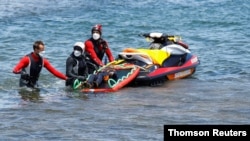 Rescue workers carry the body of a dead person after a boat with 46 migrants from the Maghreb region capsized in the beach of Orzola, Canary Islands, Spain, June 18, 2021.