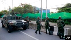 Thai soldiers take up position on a street outside the Center for the Administration of Peace and Order (CAPO) after soldiers were sent in to seize the center Tuesday, May 20, 2014.