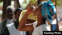 FILE - A woman takes the first dose of oral vaccine against cholera during an epidemic in Tougnifili, Guinea. (Courtesy David Di Lorenzo/MSF)