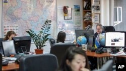 FILE - Kyiv Post chief editor Brian Bonner, right, and other journalists work at their desks in Kiev, Ukraine, Dec. 8, 2017. 