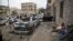 A man rests next to his car destroyed by Saudi-led airstrikes in Sana'a, Yemen, May 27, 2015.