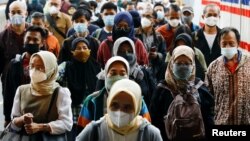 Orang-orang yang memakai masker pelindung berjalan melalui peron stasiun kereta api pada jam sibuk sore hari saat varian omicron terus menyebar, di tengah pandemi COVID-19, di Jakarta, 3 Januari 2022. (Foto: Reuters)