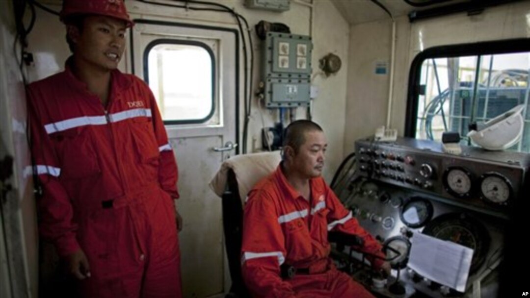 Chinese technicians operate drilling equipment on an oil rig in Paloich, southern Sudan, Nov 17, 2010
