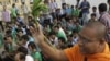 A Cambodian Buddhist monk sprinkles holly water to villagers who set a prayer rally to save rain forests in front of Royal Palace in Phnom Penh, Cambodia, Thursday, Aug. 18, 2011. Hundreds of villagers prayed at the spirit's shrine, demanding the governme