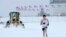 Snow is plowed behind a jogger running on the Washington Monument grounds in Washington. Snow fell in parts of the Mid-Atlantic and Northeast as winter-weary motorists faced another potentially treacherous commute, just days before the start of spring.