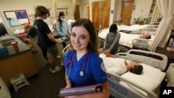 FILE - First year nursing student, Emma Champlin, poses for a photo in her clinical laboratory class at Fresno State on Wednesday, Oct. 13, 2021, in Fresno, Calif. The United States is facing a nursing shortage, and a Boston startup is looking for solutions.