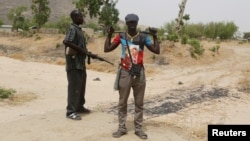 FILE - Members of a civilian vigilante group stand guard at the border with Nigeria in Kerawa, Cameroon, March 16, 2016. Kerawa is on the border with Nigeria and is subject to frequent Boko Haram attacks. 