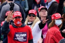 Partidarios del presidente Donald Trump muestran con sus manos el número cuatro, pidiendo un nuevo mandato para su candidato durante un evento electoral en Londonderry, New Hampshire, el domingo 25 de octubre de 2020.