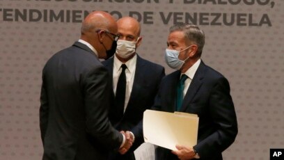 ARCHIVO - Los delegados jefes para las negociaciones sobre Venezuela, el oficialista Jorge Rodríguez y el opositor Gerardo Blyde, se saludan en Ciudad de México, el 13 de agosto de 2021.