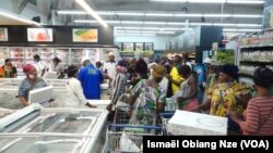 Des Gabonais à l’intérieur du magasin pour retirer les kits alimentaires, à Libreville, le 7 mai 2020. (VOA/Ismaël Obiang Nze)