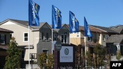 FILE - A sign advertising new homes is posted at a housing development in Dublin, California.