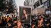 FILE - A protester holds a portrait of Mahsa Amini during a demonstration in support of the young Iranian woman, who died after being arrested in Tehran by the Islamic Republic's morality police, on Istiklal Avenue in Istanbul, Sept. 20, 2022.