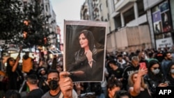 FILE - A protester holds a portrait of Mahsa Amini during a demonstration in Istanbul, Turkey, on Sept. 20, 2022. Amini's family has been banned from traveling to Europe to collect a rights prize awarded to her posthumously, their lawyer said on Dec. 9, 2023.